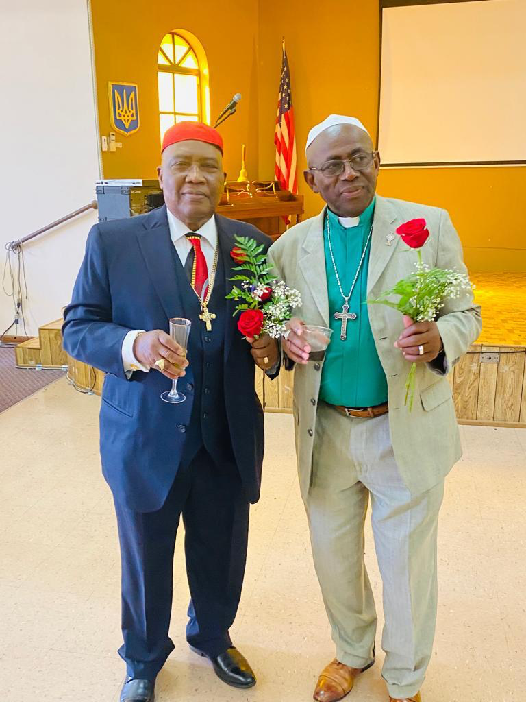 Two people sharing a moment of fellowship with flowers inside a church